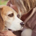 Woman cuddling dog