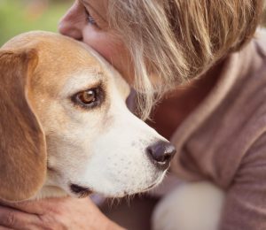 Woman cuddling dog