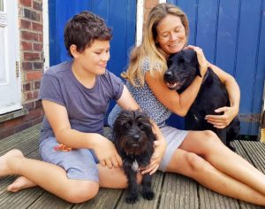 Mother and son holding black dogs