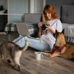 Dog, cat and woman sitting in living room