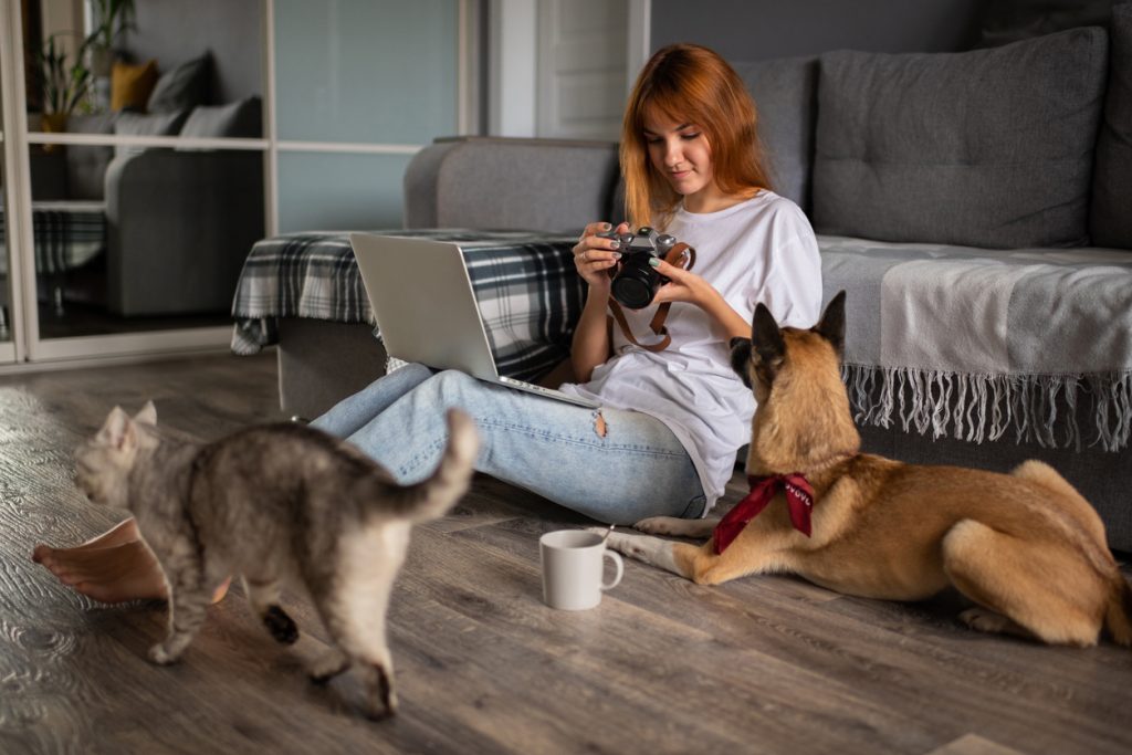 Dog, cat and woman sitting in living room