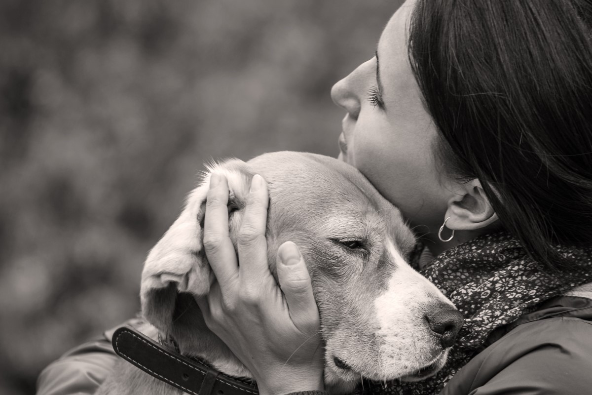 Woman cuddling dog