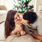 Man and woman kissing cat