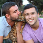 Men kissing cat