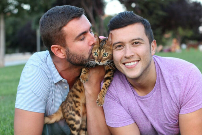 Men kissing cat