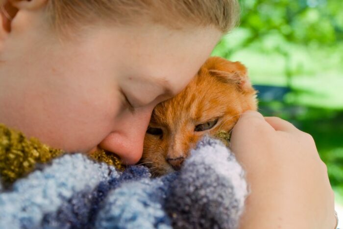 Girl cuddling ginger cat