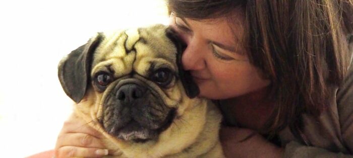 Woman cuddling dog