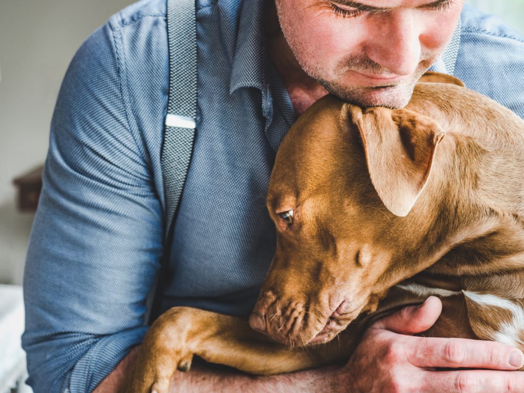 Man cuddling dog