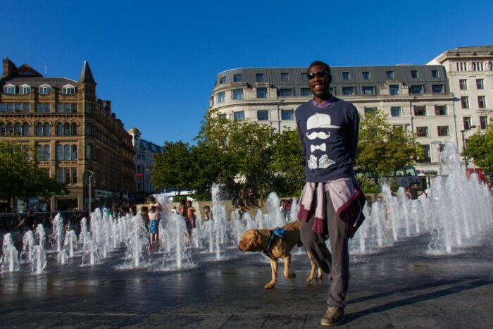 Man walking dog near water fountains