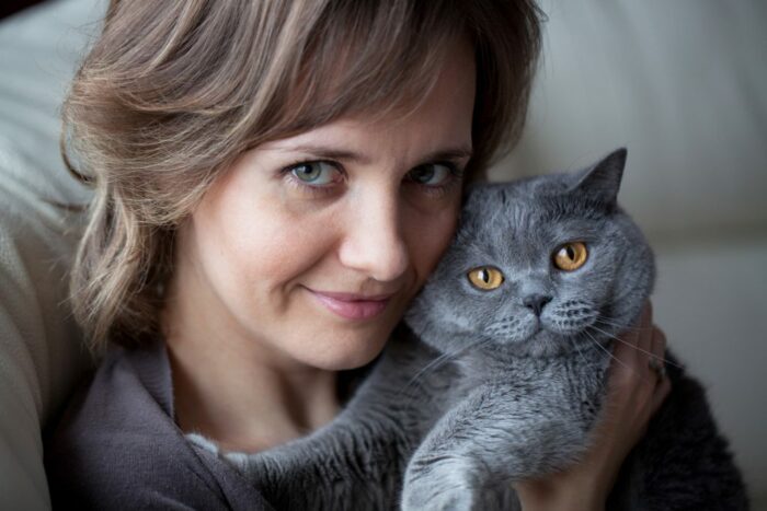 Woman cuddling black cat