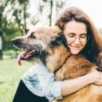 Woman cuddling dog