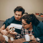 Couple stroking dog on man's lap